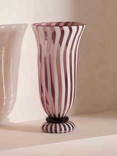 two striped vases sitting next to each other on a table