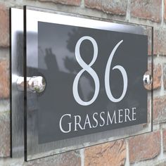 a sign on the side of a brick wall that says 86 grasmere