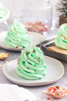 green frosted cupcakes on white plates with sprinkles