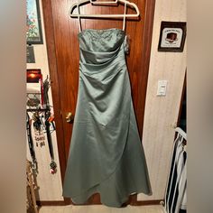 a dress hanging on a hanger in front of a door