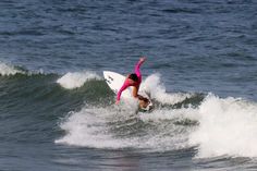 a person riding a surf board on a wave in the ocean with their arms up