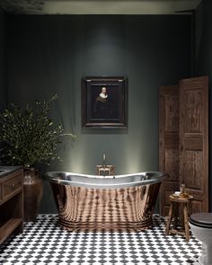 a bathroom with a checkered floor and an old fashioned bathtub in the center