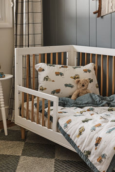 a teddy bear sitting on top of a bed next to a chair and table in a child's room