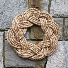 a rope hanging on the side of a stone wall with an ad for handmade