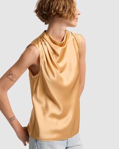 Fits like: Sleeveless shirt with draped neckline and relaxed fit. Feels like: Light and silky. The Details: 100% Silk Warm gold shade Chic Draped Satin Top, Elegant Drapey Sleeveless Top, Chic Gold Satin Top, Spring Gold Silk Top, Gold Silk Top For Spring, Gold Silk Tops For Spring, Chic Gold Satin Blouse, Summer Silk Draped Top, Silk Draped Blouse