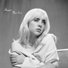 a black and white photo of a woman with her arms folded over her chest, looking at the camera