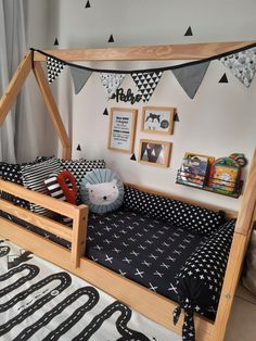 a child's bed with black and white decor on the walls, along with other toys