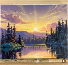 a painting of a sunset over a lake with pine trees and mountains in the background