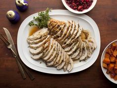 sliced chicken on a plate with cranberry sauce and carrots next to it