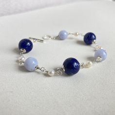 Rosary bracelet with natural Lapis Lazuli, natural blue Chalcedony and white freshwater pearls with 925 silver. The stones are of high quality in color and size. T-bar clasp and 925 silver components. Artisanal creation, entirely done by hand. For any changes contact me without hesitation. Thank you. Length: 18 cm (7.08 inches) Lapis: 9.5/10 mm. Chalcedony: 8 mm. Pearls: 4 mm. After inspection it will be packaged in a nice gift box. Model ready for delivery. Lapis Lazuli Bracelet, Artisan Bracelets, Rosary Bracelet, Bracelet Blue, White Freshwater Pearl, Blue Chalcedony, Blue Bracelet, Lapis Lazuli, Freshwater Pearls