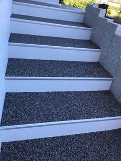 the stairs are made of concrete and have white steps with black treading on them