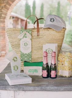 a picnic basket with two bottles of wine, popcorn and other items on the table