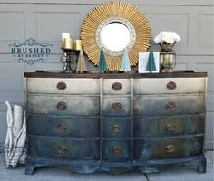 an old dresser has been painted with metallic paint and gold trimmings to give it a vintage look