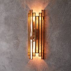 a wall light that is mounted on the side of a concrete wall with glass panels