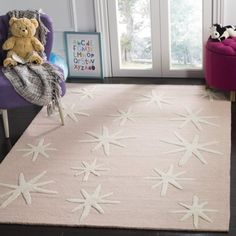 a white rug with starfishs on it in front of a purple chair and window