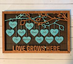 a family tree with blue hearts hanging from it's branches and the words love grows here