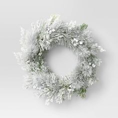 a christmas wreath with white flowers and greenery