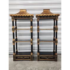 a pair of black and gold bookcases