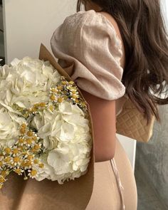 a woman holding a bouquet of white flowers