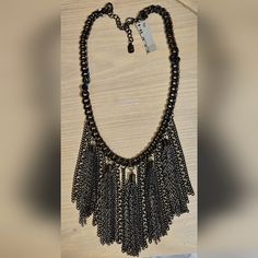 Add A Touch Of Elegance To Your Outfit With This Stunning Hugo Necklace. The Black Tassel Pendant Hangs From A Mixed Silver And Gunmetal Chain, Giving It A Unique And Stylish Look. The Lobster Closure Ensures That The Necklace Stays Securely In Place, While The Adjustable Feature Allows You To Customize It To Your Liking. This Necklace Is Perfect For Any Occasion, Whether You're Dressing Up For A Formal Event Or Adding Some Flair To Your Everyday Wear. The Engraved Design Adds A Touch Of Persona Fringe Tassel Necklace For Party, Party Tassel Necklace With Adjustable Chain, Elegant Metal Tassel Necklace For Parties, Metal Tassel Necklace With Adjustable Chain For Parties, Metal Tassel Necklace For Party, Elegant Metal Chain Necklace With Dangling Beads, Party Necklaces With Tassels And Dangle Shape, Adjustable Metal Tassel Necklace For Party, Black Metal Chain Necklace For Fashion