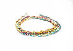 This rainbow with white braided friendship bracelet is a cheerful and light way to wear a rainbow! Breaking up the rainbow with white makes it match well with pastel or light-colored clothing, The soft, high-quality cotton used is lightweight and colorfast so you can wear it non-stop. White Braided Jewelry For Friendship, Multicolor Braided Friendship Bracelets, White Braided Friendship Bracelets, White Braided Bracelet For Friendship, White Braided Friendship Bracelet, White Braided Bohemian Bracelets, White Bohemian Braided Bracelet, Multicolor Braided Jewelry For The Beach, Multicolor Braided Jewelry For Beach