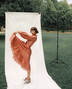 a woman standing in front of a white backdrop