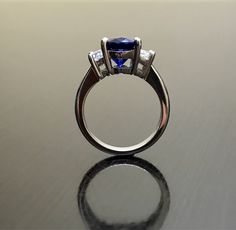 Dekara Designs Collection Metal- 90% Platinum, 10% Iridium. Stones- 1 Natural Untreated 3.88 Carat Oval Cut Ceylon Blue Sapphire. 2 Moon Cut Diamonds, F-G Color VS1 Clarity 0.77 total carats This ring is a size 6, but could be sized up or down a few sizes. This ring could be made in your specific size within 5-10 business days. Could take a little more time due to the ceylon sapphire being a rare stone. The sapphire may be a bit smaller or bigger. We can make the same design in a smaller or bigg Formal Blue Sapphire Ring Gia Certified, Blue Sapphire Three-stone Promise Ring, Blue Tanzanite Ring With Trillion Cut, Blue Three Stone Sapphire Promise Ring, Blue Sapphire Ring With Trillion Cut Diamond, Blue Trillion Cut Fine Jewelry Ring, Blue Trillion Cut Ring Fine Jewelry, Blue Brilliant Cut Diamond Ring With Round Band, Blue Brilliant Cut Round Band Diamond Ring