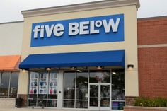 a five below storefront with the front door open and it's blue awning