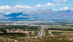 an aerial view of a highway in the desert with mountains in the backgroud