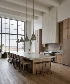 a kitchen with wooden floors and large windows