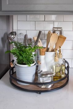 a potted plant sitting on top of a kitchen counter next to utensils