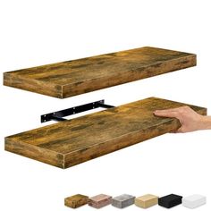 a hand is holding the edge of a wooden shelf with several different colors and sizes