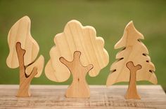 three wooden trees on a table with grass in the background