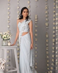 Description: The Classic Silhouette of a saree in ice blue, overlaid with whimsical details of a floral trellis border of hues of cream and silver. The saree is paired with a plain corset tube top blouse and embroidered belt.Colour Ice blueFabric GeorgetteCare Dry Clean onlyFit Tailored*Please note: The belt is included in the outfit Desi Fits, Cotton Saree Designs, Embroidered Belt, Pakistani Outfits, Classic Silhouette, Cotton Saree, Ice Blue, Tube Top, Saree Designs