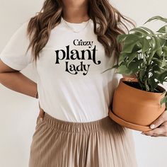 a woman holding a potted plant and wearing a t - shirt that says crazy plant lady