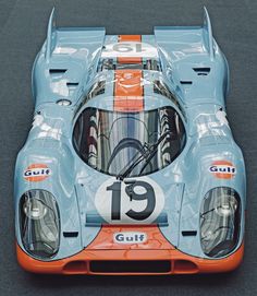 an orange and blue race car with the number 19 gulf