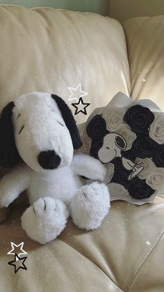 a white stuffed dog sitting on top of a couch next to a star shaped pillow