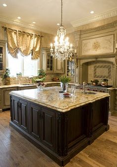 a large kitchen with an island and chandelier in the middle of the room