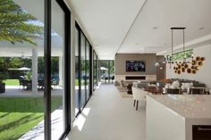 a large open living room and dining area with glass doors leading to the back yard