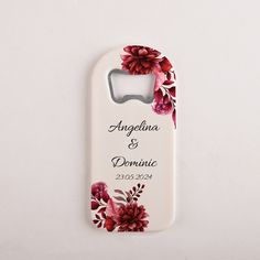 a white bottle opener with red flowers on the front and back cover that says, anselina & domonie