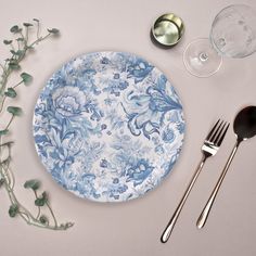 a blue and white plate sitting on top of a table next to utensils