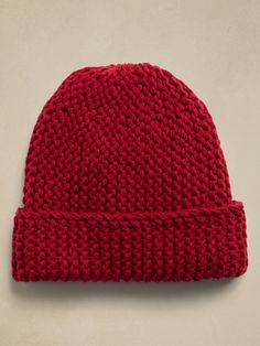 a red knitted beanie on a white surface