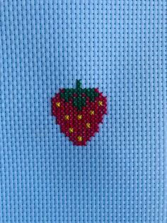 an embroidered strawberry on a blue shirt