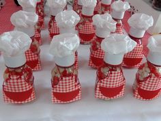 small red and white checkered cups with chefs hats on them sitting on a table