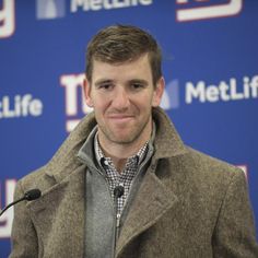 a man standing at a microphone in front of a blue wall with the words metlife on it