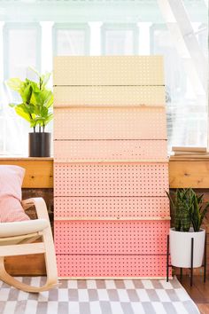 a rocking chair sitting in front of a stack of pink and yellow wall panels