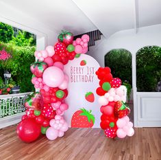 there is a very large balloon arch with strawberrys on it