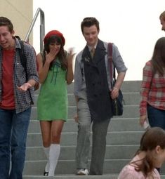 a group of young people walking up some steps and talking on their cell phones,