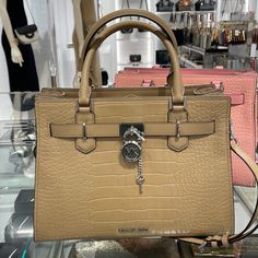 Michael Kors Hamilton Medium Satchel Color: Camel New With The Tag Authentic Michael Kors Logo At Front Snap Top Closure Silver -Toned Hardware Mk Key & Lock On Front 4 Protective Feet Custom Mk Fabric Lining 1 Slip-In Pockets 1 Zipper Pocket 13" (L) X 9"(H) X 5"(D) Strap: 4", 18"- 24" Very Clean, Smoke-Free And Pet-Free Environment. Brown Leather Satchel, Michael Kors Bedford, Michael Kors Mercer, Michael Kors Satchel, Michael Kors Logo, Michael Kors Selma, Black Satchel, Bags Michael Kors, Leather Satchel Handbags