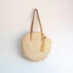 In Stock Fast Shipping From Los Angeles Carry your essentials in sweet, summery style with this Straw Circle Tote Handbag from Elena Handbags. This chic circular bag makes a great option for your warm weather errands like the farmer's market or thrifting, boasting an open-top design that provides quick and easy access to items inside. Double faux leather shoulder straps with whipstitch detailing add more texture to the look, while also providing comfortable carry over your shoulder as you go abo Spring Straw Bag With Tassels For Daily Use, Spring Straw Bag With Tassels, Natural Color Tassel Beach Bag For Spring, Natural Tassel Beach Bag For Spring, Natural Color Beach Bag With Tassels For Spring, Spring Beach Bag With Tassels For Daily Use, Summer Straw Bag With Tassels For Daily Use, Everyday Bohemian Braided Straw Bag, Bohemian Braided Straw Bag For Everyday Use